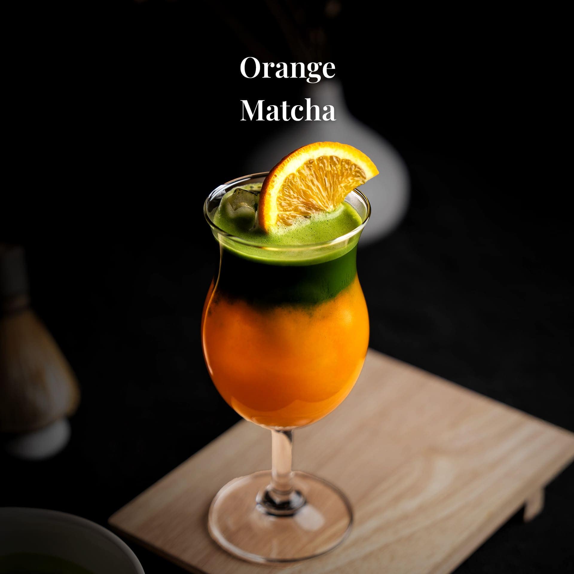 เครื่องดื่มซิกเนเจอร์ ออเรนจ์มัทฉะ ของ Davin Cafe เป็นชั้นสีเขียวของมัทฉะบนน้ำส้มสด ตกแต่งด้วยชิ้นส้ม.