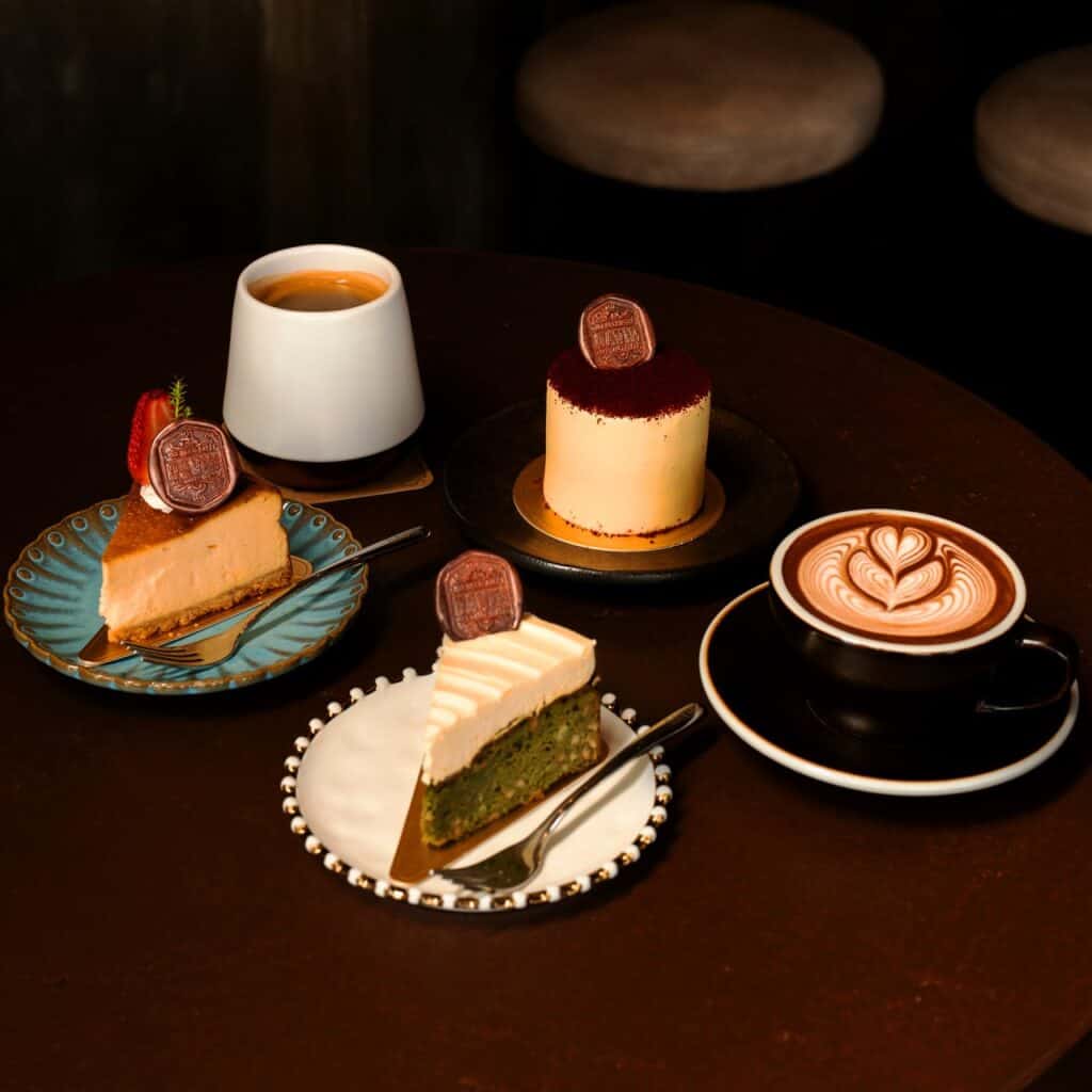 เค้กโฮมเมด 4 ชิ้นและขนมหวานหลากหลายเมนู พร้อมกาแฟเอสเพรสโซและลาเต้อาร์ต บนโต๊ะใน Davin Cafe คาเฟ่รามอินทรา.