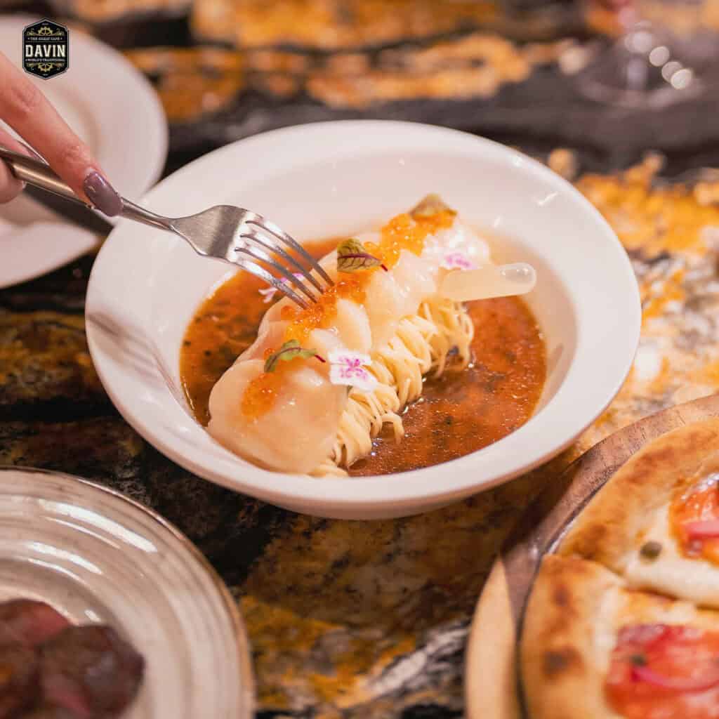 ภาพระยะใกล้ของเมนูอาหารทะเลสุดสร้างสรรค์ (หอยเชลล์หรือพาสต้า) พร้อมไข่ปลาคาเวียร์ ที่แสดงถึงคุณภาพและเมนูระดับพรีเมียมของร้านอาหารจัดเลี้ยง Davin Cafe.