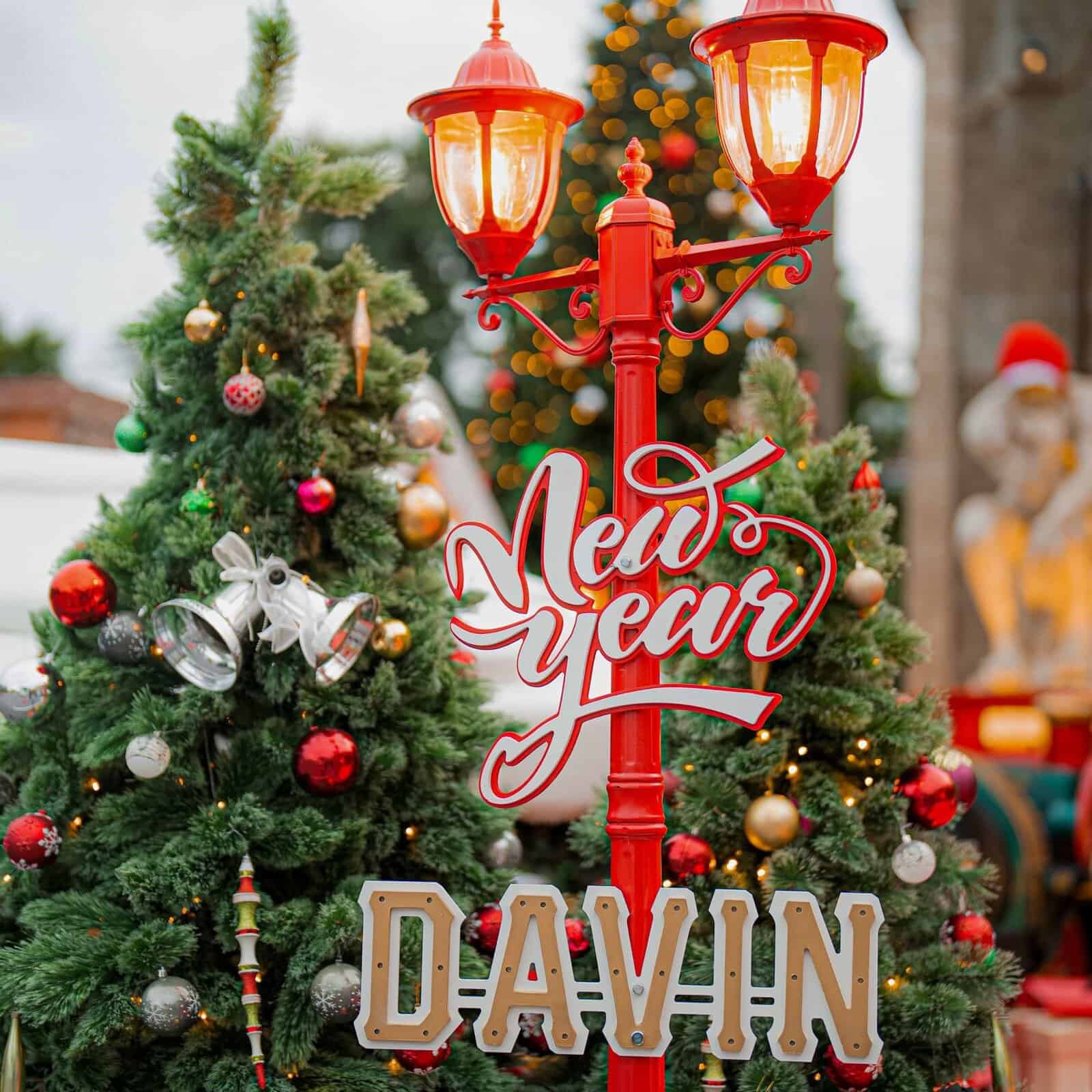 เสาไฟสีแดงที่ตกแต่งด้วยป้าย "New Year" และลูกบอลคริสต์มาสหลากสีสัน ที่ Davin Cafe.