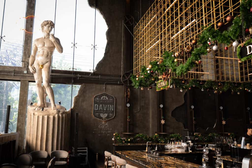 บรรยากาศภายในสถานที่จัดงานคริสต์มาส 2025 สไตล์อาร์ตคลาสสิก ผสานประติมากรรม ศิลปะอุตสาหกรรม และของตกแต่งเทศกาลคริสต์มาส เหมาะสำหรับงานเลี้ยงคริสต์มาส งานฉลองปลายปี และอีเวนต์พรีเมียม