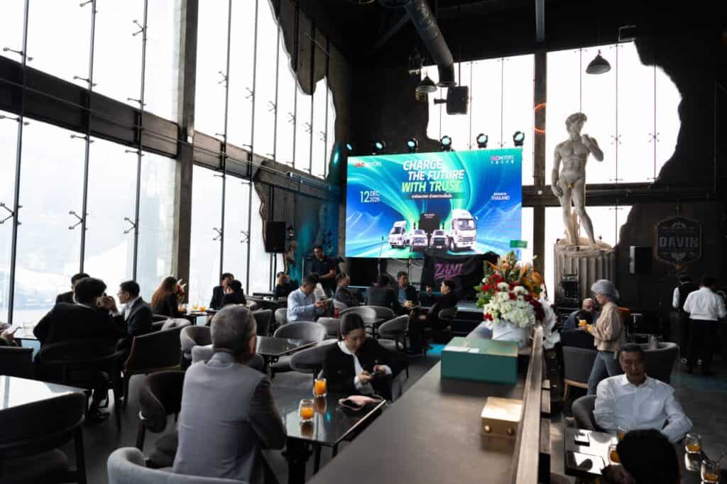 A corporate party setting inside a restaurant venue, where business guests engage in networking and conversations during a company event, combining dining experience with an organized business-focused atmosphere.