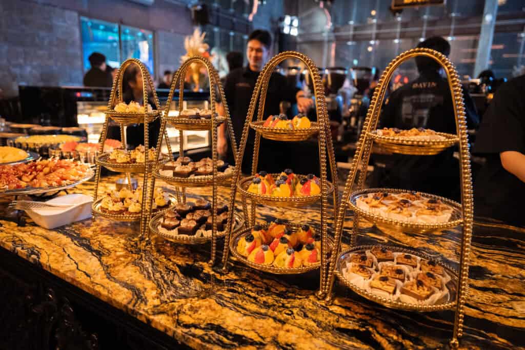 ดขนมหวานที่จัดเรียงอย่างประณีตบนแท่นเสิร์ฟภายในร้านอาหารจัดเลี้ยง สะท้อนมาตรฐานการนำเสนออาหารสำหรับงานเลี้ยงบริษัทและอีเวนต์ระดับพรีเมียม