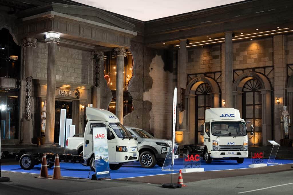 A modern event venue showcasing an automotive brand launch with outdoor display space, architectural backdrop, and a professional exhibition atmosphere