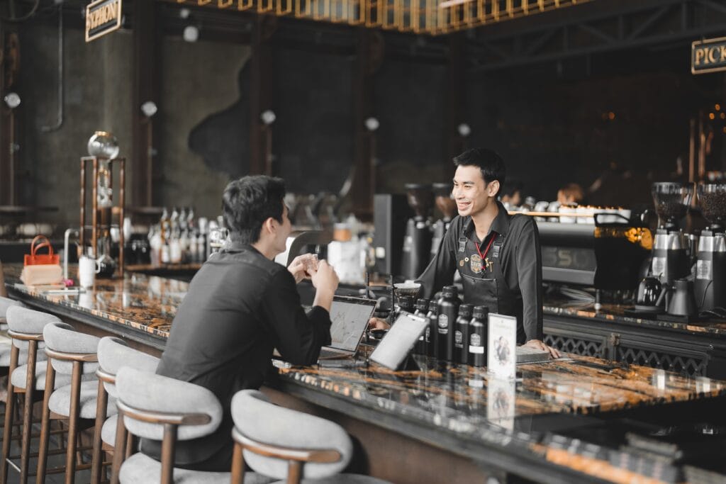 Barista interacting with a customer at Davin Cafe, a premium coffee shop in Ramintra known for friendly service and quality coffee