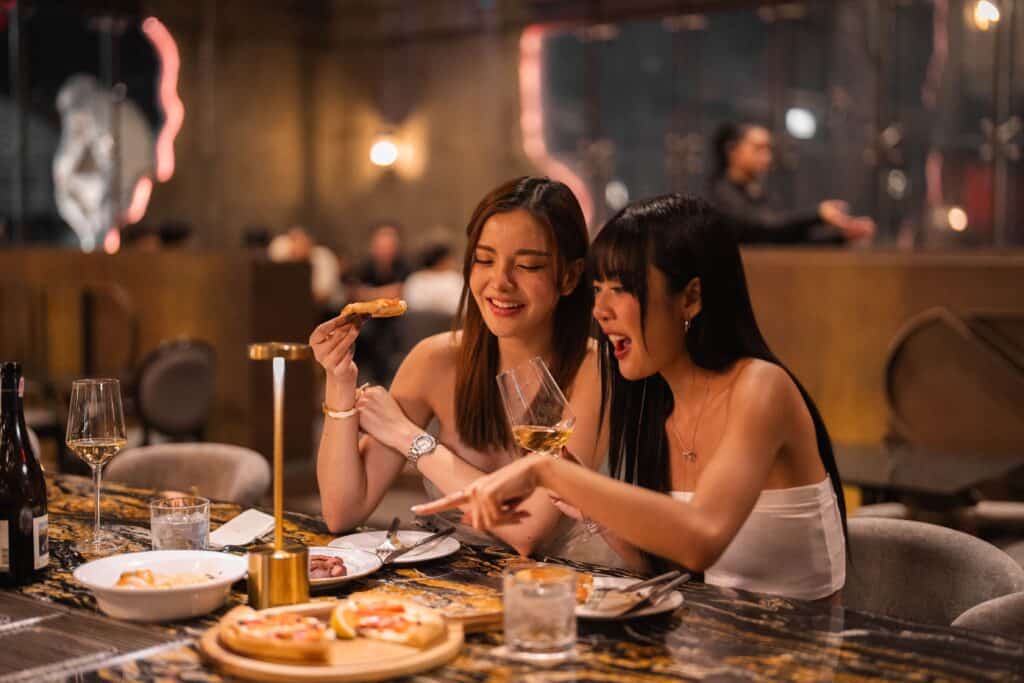 Friends enjoying a relaxed dinner experience at Davin Cafe, a stylish cafe along the Ramintra Expressway, featuring warm lighting, thoughtfully plated dishes, and an inviting atmosphere ideal for social dining and memorable evenings.