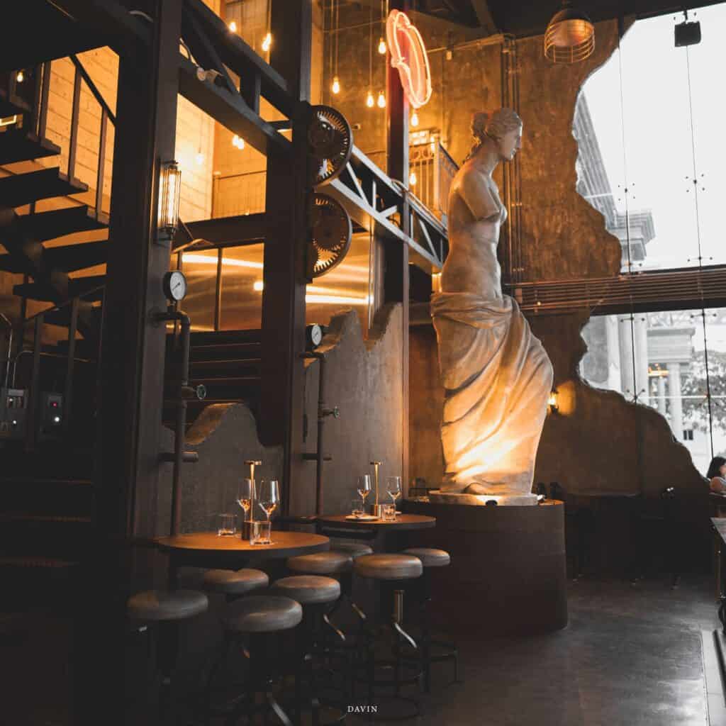 The industrial-chic interior of Davin Cafe blends classical art and warm ambient lighting, positioning it as a bakery Bangkok venue where design, atmosphere, and curated dining experiences elevate far beyond ordinary cafés.