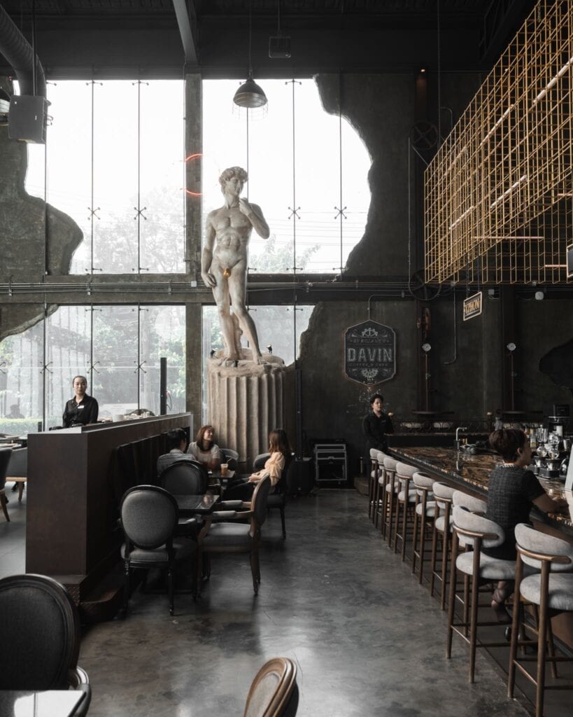 Grand interior of Davin Cafe, a European-style coffee shop along Liab Duan Ramintra featuring high ceilings, bar seating, and classical sculpture design in Bangkok