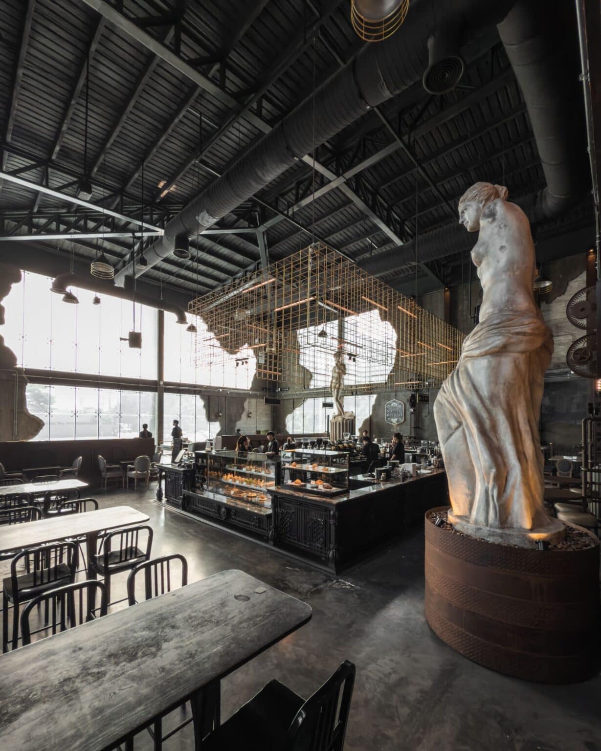 Iconic high-ceiling interior of Davin Cafe, a landmark European-style coffee shop along Liab Duan Ramintra in Bangkok featuring grand sculpture and pastry display counter