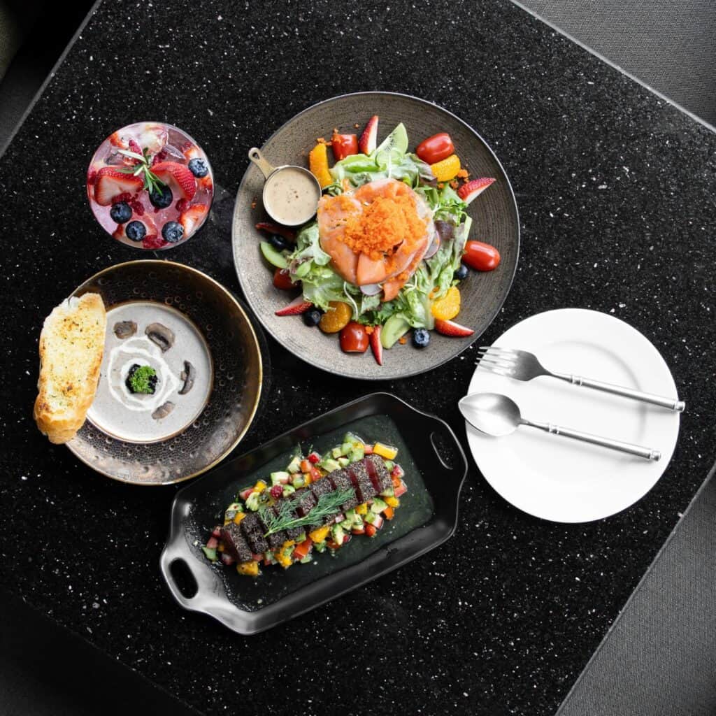 เมนูซิกเนเจอร์ของร้านกาแฟเลียบด่วน รามอินทรา Davin Cafe ประกอบด้วยสลัดแซลมอน ซุปครีม ขนมปัง และจานพรีเมียม เหมาะสำหรับมื้อกลางวันหรือพบปะลูกค้า