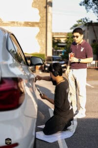 รถยนต์และคนสองคนในกิจกรรมทำบุญรถยนต์ที่งานอีเวนต์ The First Ultimate เที่ยวสุดโลก 15 พ.ย. 2025.