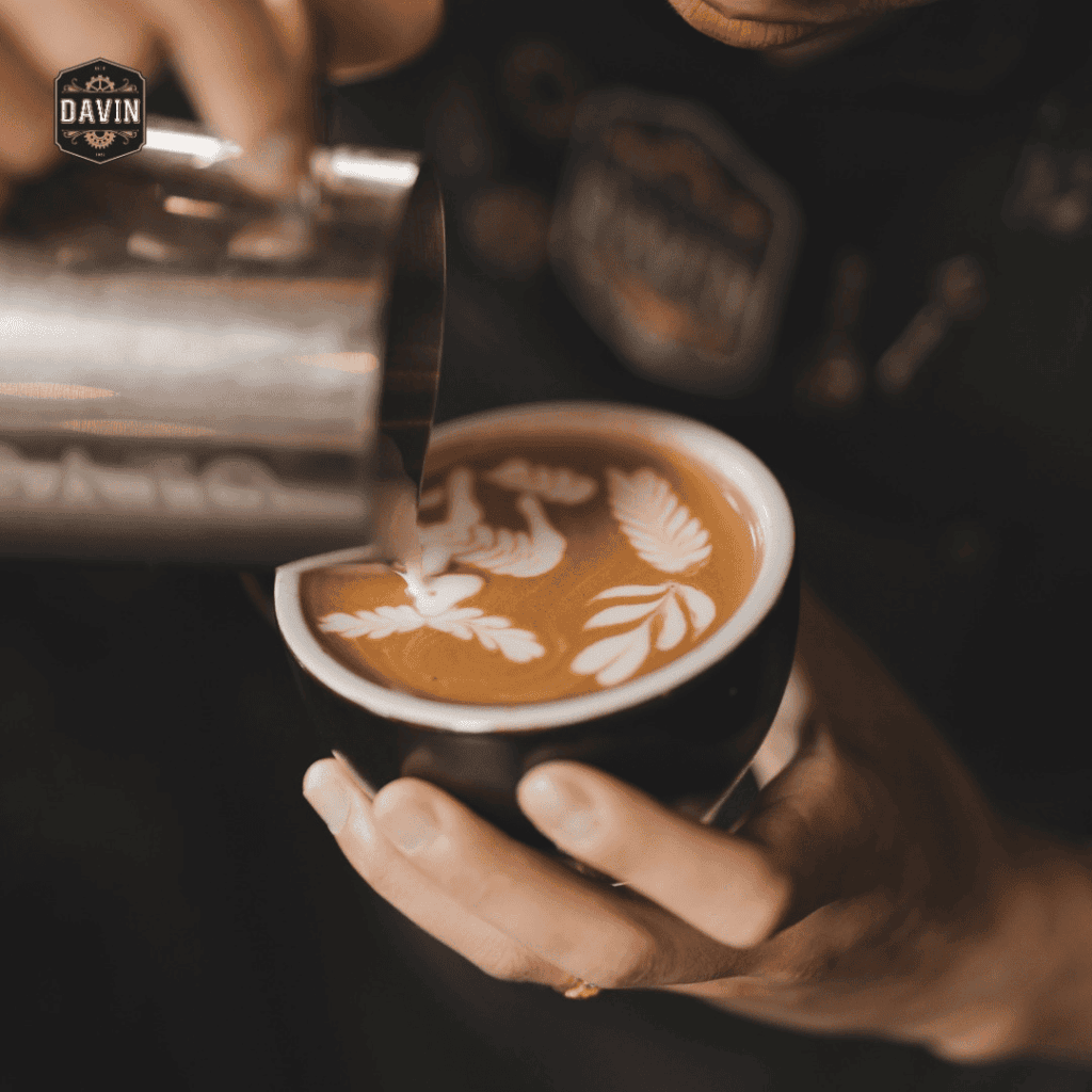 Latte art barista creating latte art pattern on specialty latte coffee using milk pouring technique in a premium coffee cafe