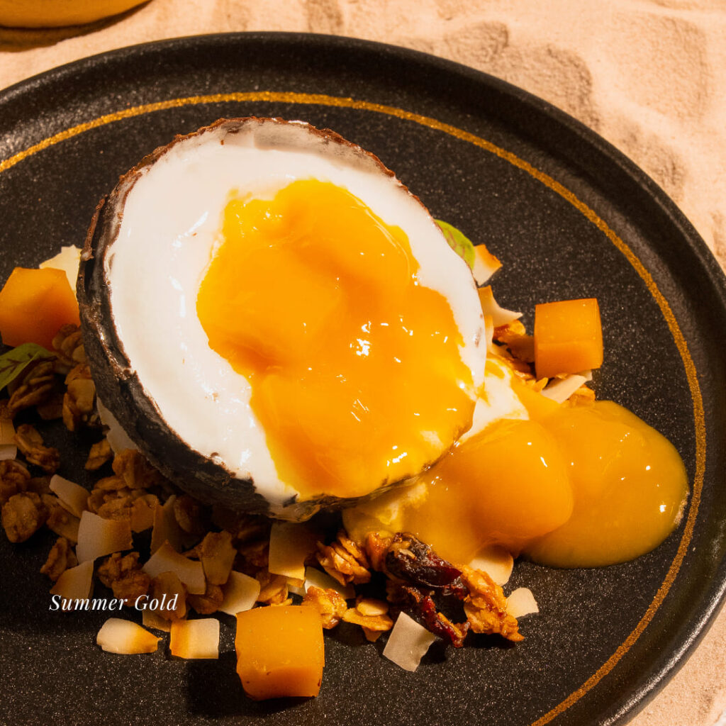 The 'Golden Hour' refreshing summer drink menu, a vibrant layered cocktail served next to a miniature beach chair, perfect for networking or casual socializing in a sophisticated Roman Loft ambiance.