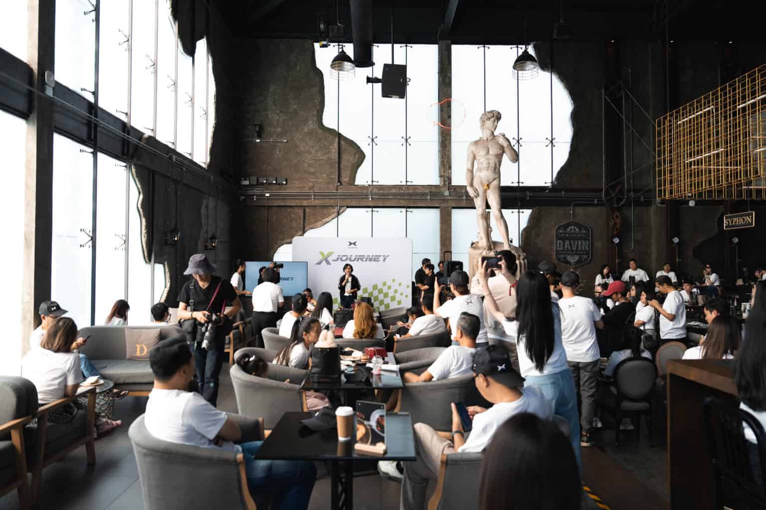 ดินเนอร์ในงานอีเวนต์ X Peng ที่ Davin Cafe พร้อมผู้เข้าร่วมจำนวนมากในบรรยากาศทันสมัย.