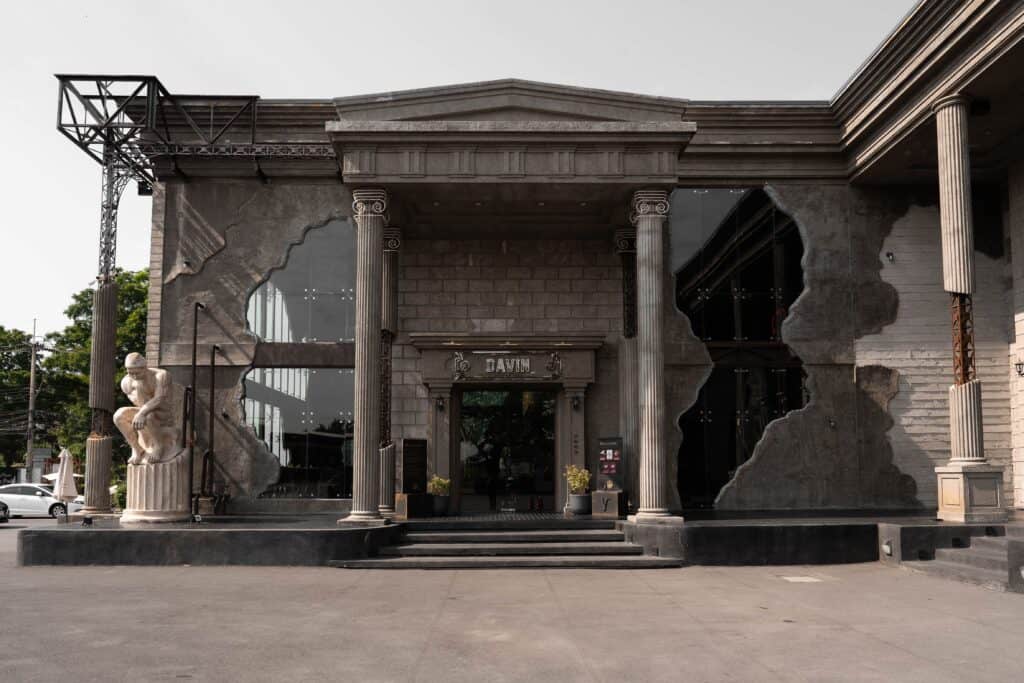 The grand entrance of Davin Cafe featuring classical columns and a European-inspired façade, offering a distinctive architectural experience for those seeking a refined European-style café in Bangkok