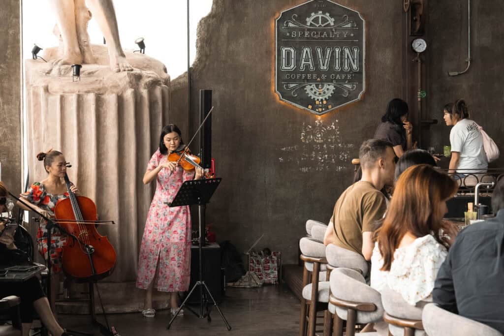 Live music performance inside Davin Cafe during the Songkran season, where guests relax with drinks while enjoying an elevated café atmosphere in Bangkok