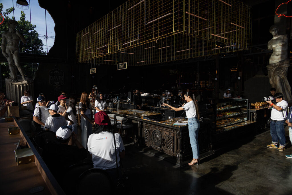 A live coffee brewing demonstration at Davin Cafe with attendees gathered around, showcasing an interactive workshop environment ideal for hands-on seminars and experiential events in Bangkok