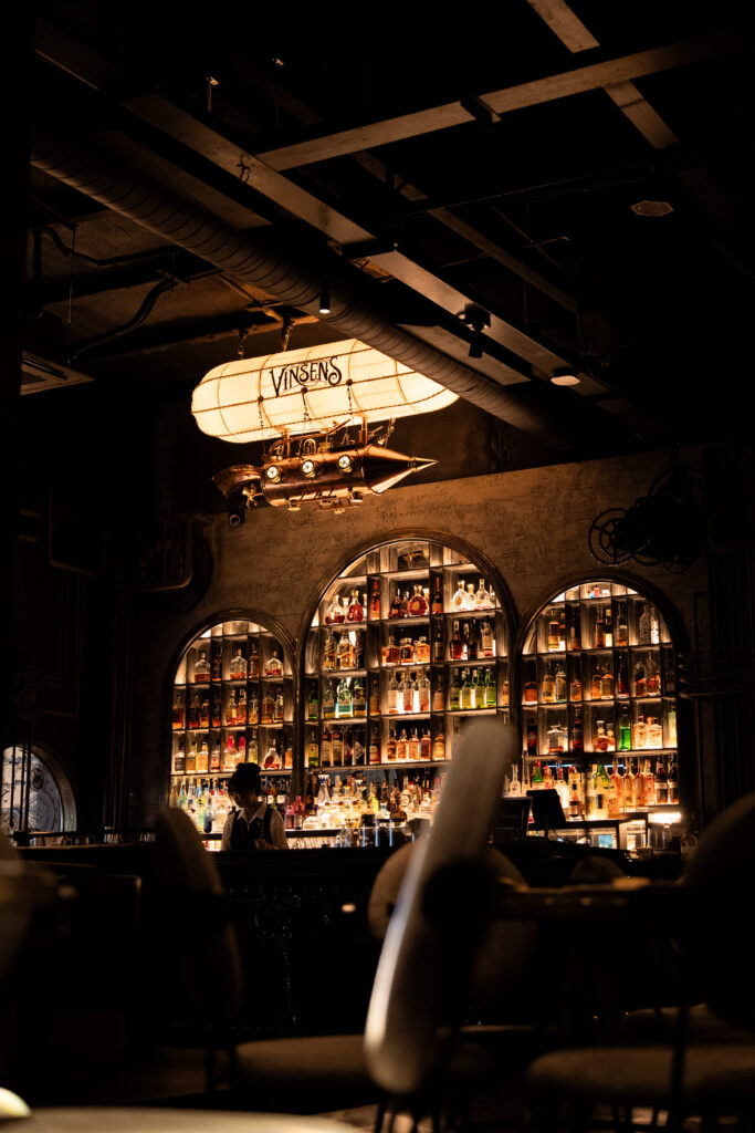 โซนบาร์ของ Vinsens ร้านนั่งชิล รามอินทรา ที่ตกแต่งด้วยชั้นวางเครื่องดื่มระดับพรีเมียมและแสงไฟอบอุ่น สร้างบรรยากาศหรูสำหรับการนั่งดื่มและสังสรรค์ยามค่ำคืน