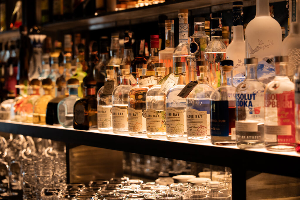 Curated collection of premium spirits and imported liquor bottles displayed inside a luxury cocktail bar in Bangkok, crafted for elevated dining and refined nightlife experiences