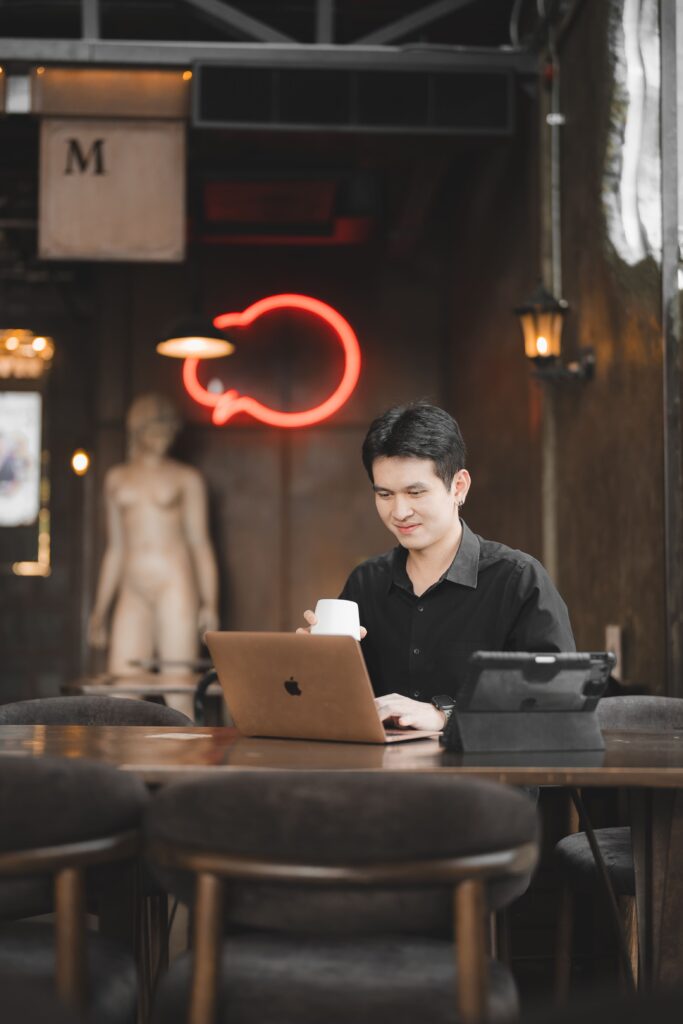Customer working on a laptop at DAVIN CAFE, a stylish cafe near me in Bangkok, offering a calm work-friendly atmosphere, premium interior design, and an ideal setting for remote work and casual meetings