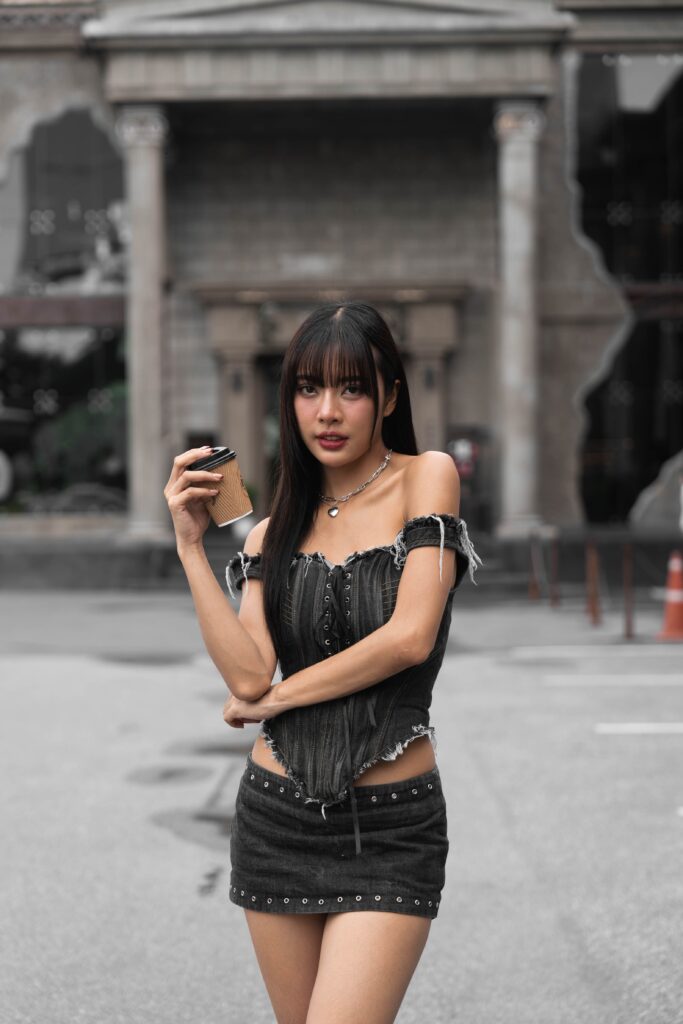 Stylish woman holding coffee in front of DAVIN CAFE, a luxury cafe near me on Ram Intra Expressway Bangkok, featuring premium atmosphere, aesthetic photo spots, lifestyle vibes, and trendy specialty coffee experience