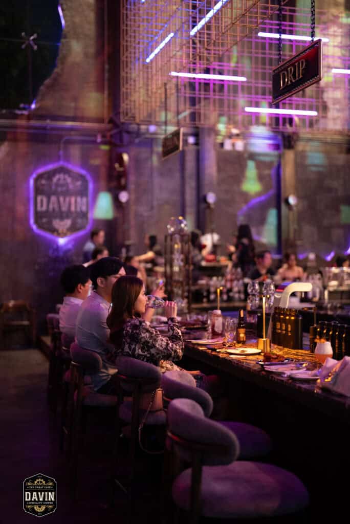 Guests seated around the bar area at Davin Cafe during an evening event, showcasing a Bangkok fan meet venue with stylish lighting, spacious seating, and premium food and beverage service for fan gatherings, artist events, and private community experiences.