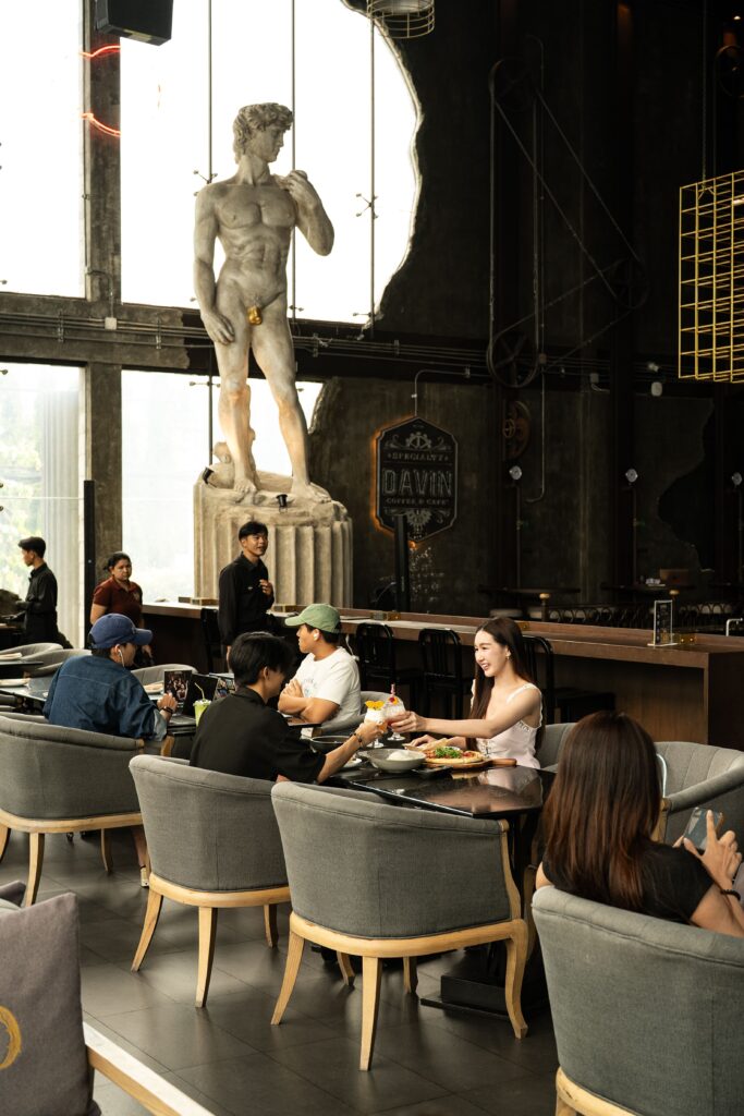 Guests enjoying food and drinks at DAVIN CAFE, a premium Liap Duan restaurant featuring a grand high-ceiling interior, iconic classical sculpture, and an upscale dining atmosphere for special occasions and social gatherings