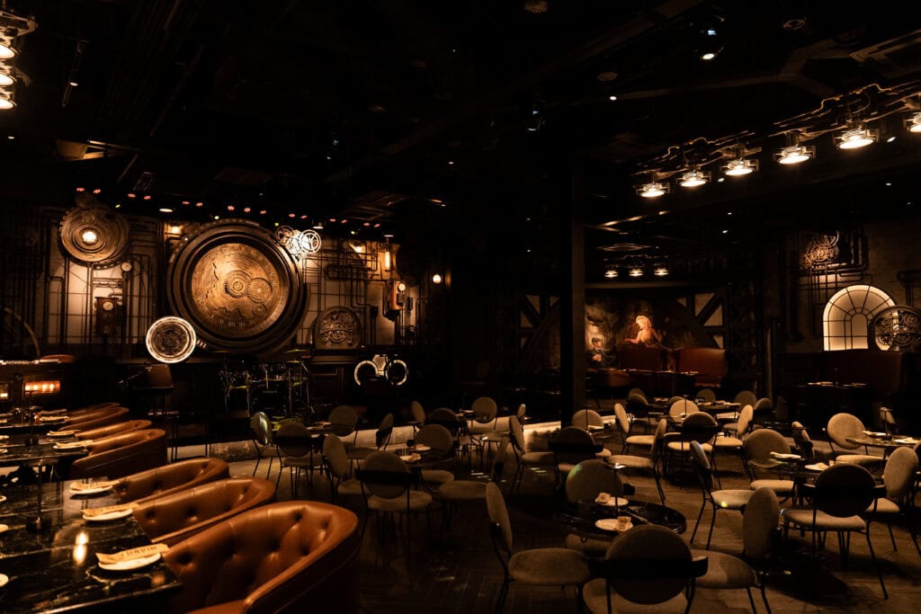 Wide interior view of VINSENS, a stylish chill bar in Bangkok with live music stage, warm lounge lighting, spacious seating zones, and a refined atmosphere for after-work drinks, relaxed dinners, music nights, and intimate social gatherings.