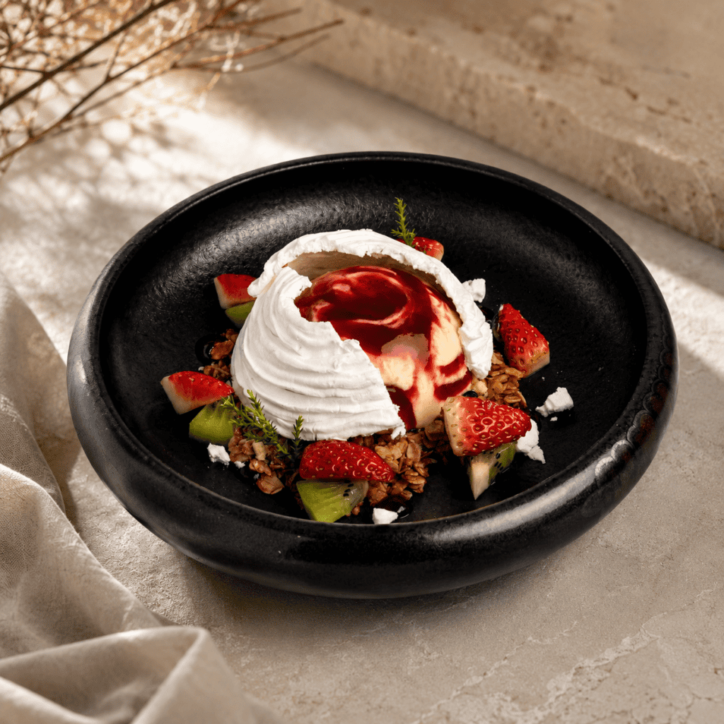 Pavlova-style dessert at Davin Cafe with crisp meringue, berry sauce, strawberries, kiwi, and granola, highlighting a refined cake shop and dessert cafe experience on Liab Duan Road for guests who enjoy fresh, elegant sweets.