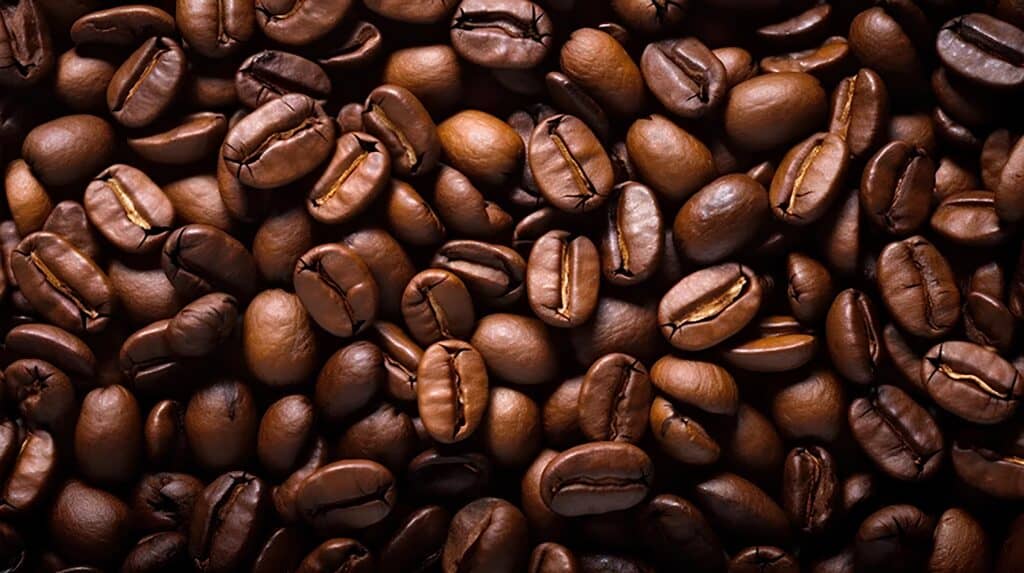 ภาพระยะใกล้ของเมล็ดกาแฟคั่วสีน้ำตาลเข้มที่เห็นผิวสัมผัสและรอยแตกของเมล็ดอย่างชัดเจน ใช้สื่อบรรยากาศงาน Flavor Exchange ที่เน้นการสำรวจกลิ่น รสชาติ ระดับการคั่ว และรายละเอียดของกาแฟก่อนเข้าสู่ประสบการณ์ cupping อย่างจริงจัง