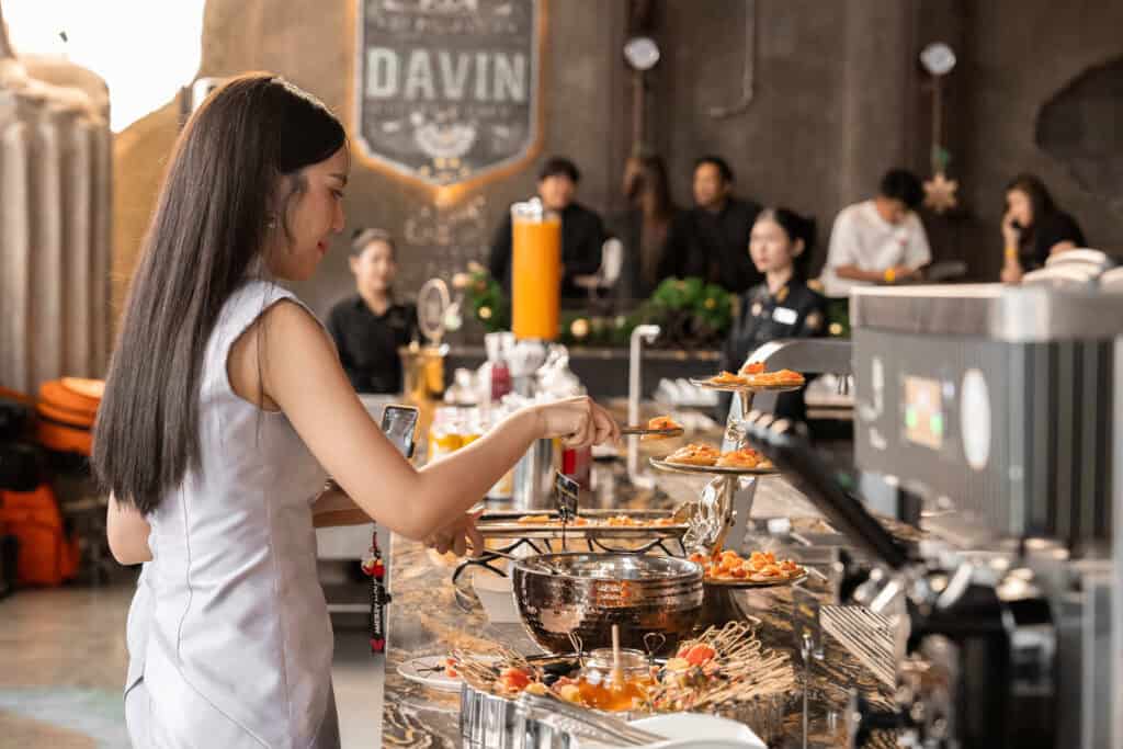 Ramintra restaurant at DAVIN CAFE featuring a guest selecting premium European-inspired dishes at the dining counter in a spacious and elegant setting, perfect for family dining, birthday celebrations, group gatherings, and special occasions in Bangkok.