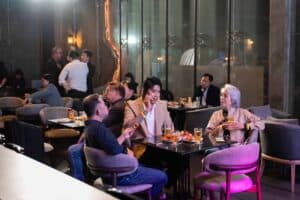 Business guests relaxing and chatting over drinks in the comfortable lounge area of our corporate party venue in Bangkok.