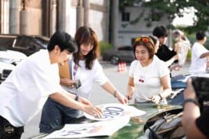Participants preparing a car with decals for a rally at Davin Cafe, a versatile event space rental in Bangkok.