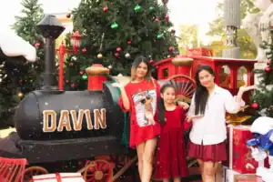 A family enjoying the snowy Christmas decorations and the Davin train prop at our outdoor event space rental in Bangkok.