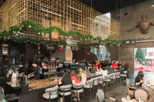The bustling coffee bar area at Davin Cafe adorned with Christmas garlands, highlighting the venue's atmosphere as an event space rental in Bangkok.
