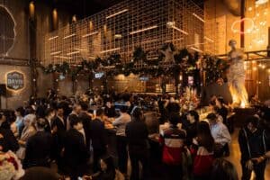 A large crowd of attendees gathering and socializing in the main hall of Davin Cafe, a spacious fan meeting venue in Bangkok.