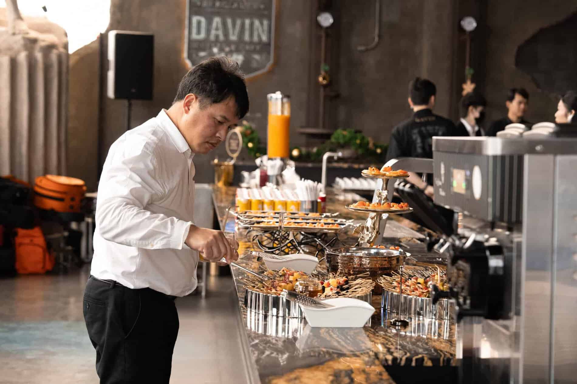 A guest selecting food from a catered buffet line during an event at our indoor meetup space in Bangkok.