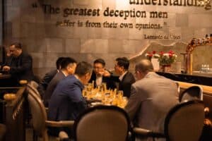 A group of executives engaged in a lively discussion over dinner at our exclusive corporate party venue in Bangkok.