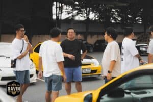 A group of friends casually chatting during a car club gathering at our outdoor meetup space in Bangkok.