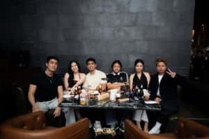 A group of friends enjoying food and drinks together at a comfortable lounge table in Davin Cafe, a great meetup space in Bangkok.