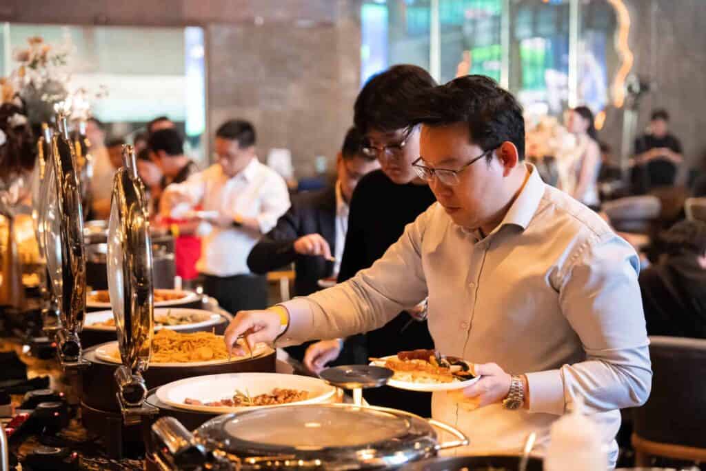 An attendee enjoying the premium buffet catering during an evening event at a premier corporate party venue in Bangkok.