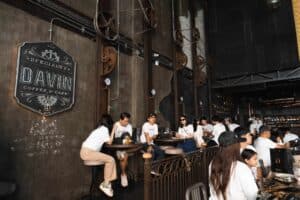 Colleagues relaxing and socializing along the long bar counter inside our industrial-style corporate party venue in Bangkok.
