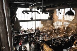 Wide high-angle interior shot of a large crowd gathering at Davin Cafe, demonstrating its massive capacity as an event space rental in Bangkok.