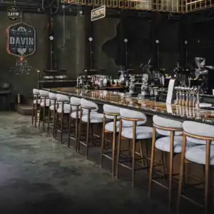A long marble counter with comfortable bar stools and coffee equipment ready to serve guests at a seminar venue in Bangkok.
