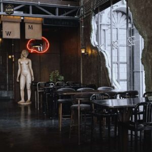 Modern industrial seating area with a classic statue and neon sign, ideal for breakout sessions at a seminar venue in Bangkok.