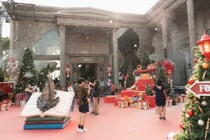 Guests enjoying a magical snowy Christmas festival in the spacious outdoor courtyard of Davin Cafe, an expansive event space rental in Bangkok.