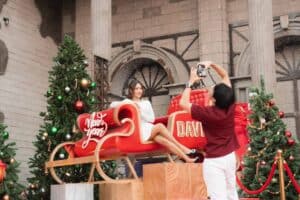 Guests taking photos on a festive red sleigh during the holiday season at Davin Cafe's outdoor event space rental in Bangkok.